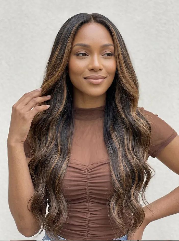 A woman with long, wavy, highlighted human hair wig by WigOutlets